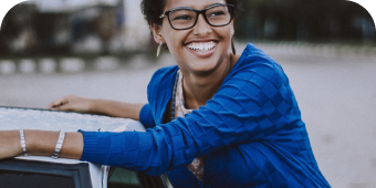 Woman sitting outdoors smiling.